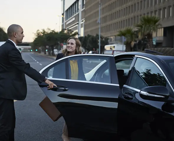 private-airport-car-service chauffeur opening door of car for a women