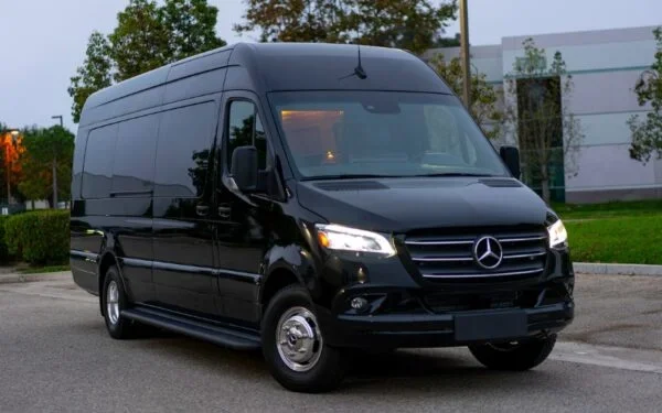 Black Mercedes-Benz Sprinter luxury passenger van parked outdoors.