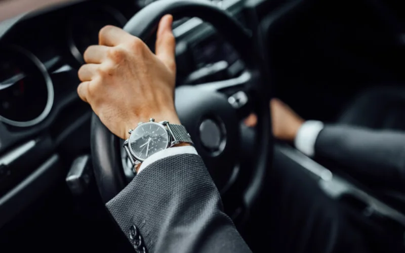 Close up of businessman hands on steering wheel