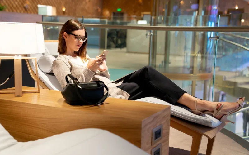 woman using smartphone in airport lounge