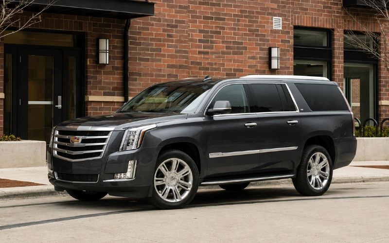 Black luxury SUV parked outside a brick building.