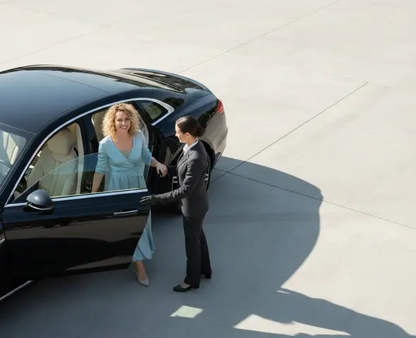 Chauffeur assisting passenger into luxury sedan in Columbus