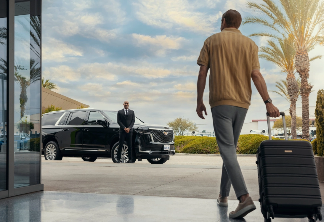 Chauffeur greeting a traveler for Columbus airport pickup in a luxury SUV