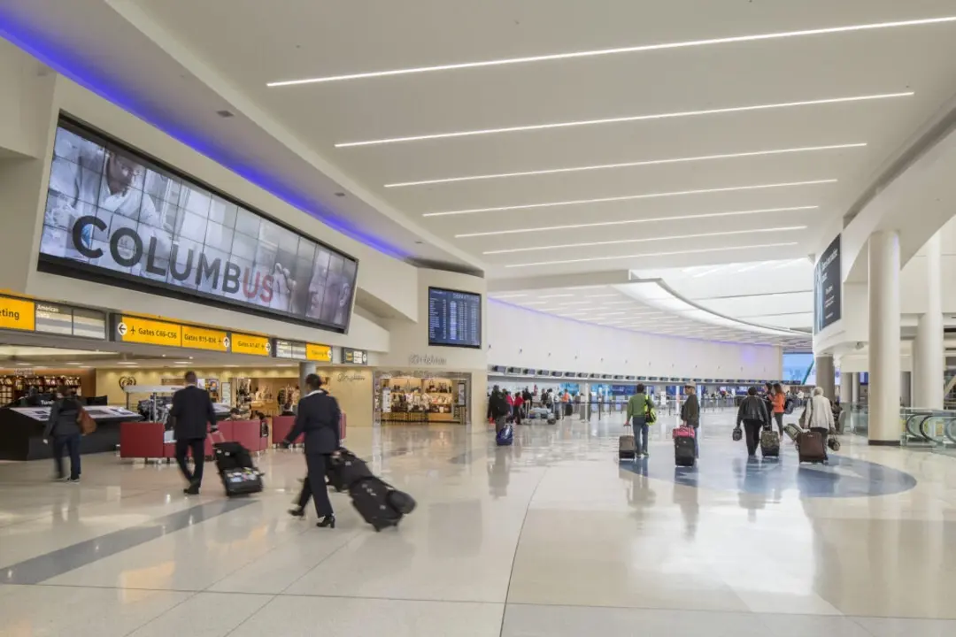 Travelers with luggage inside Columbus airport for chauffeur pickup service Travelers with luggage inside Columbus airport for chauffeur pickup service